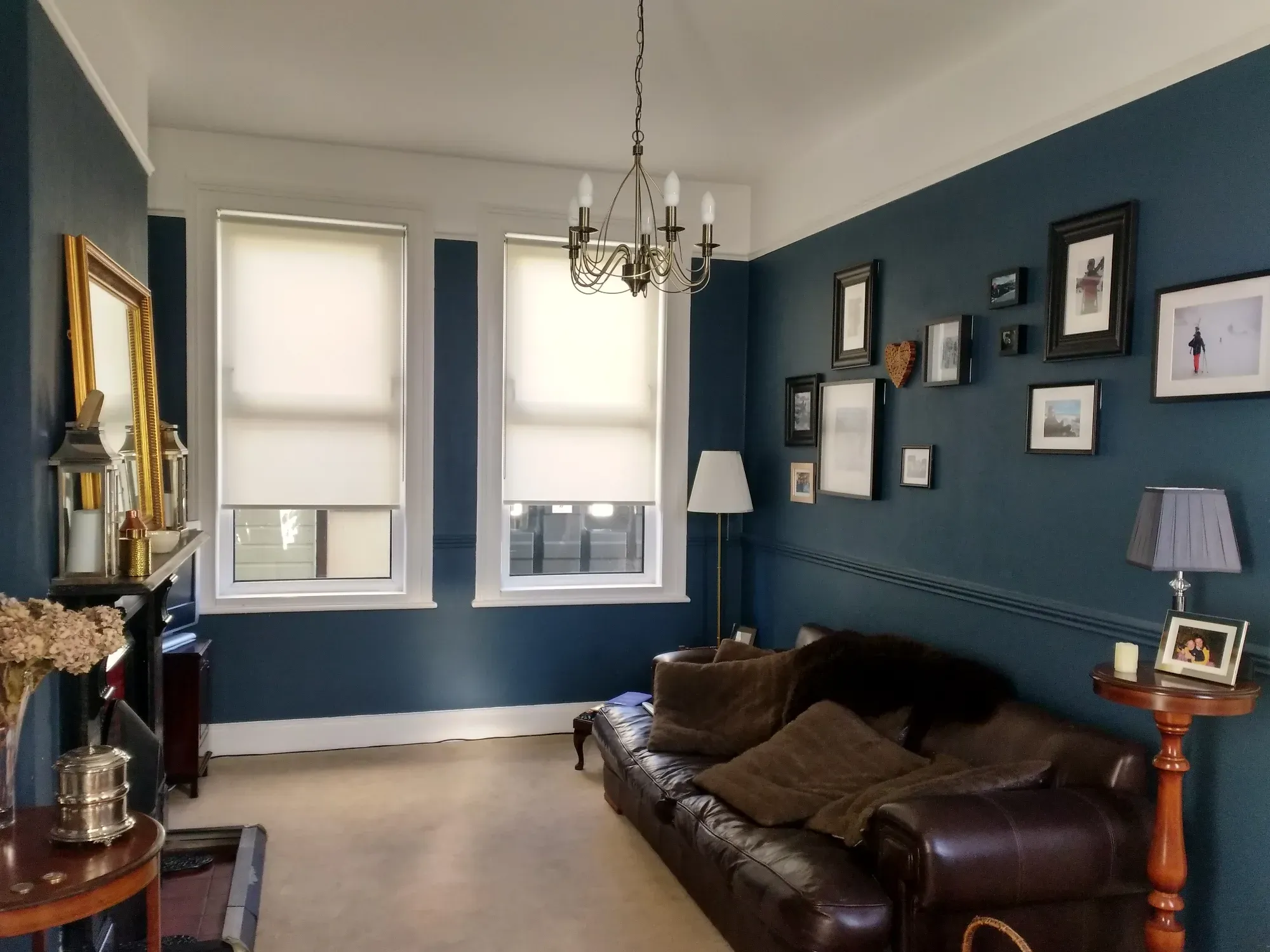 A living room painted deep blue with white woodwork